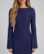 Close-up of the boat neckline and flared sleeves of the navy sparkly dress